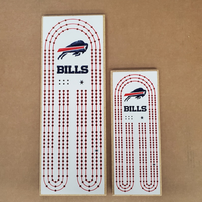 May include: Two wooden game boards with red and white circles and a blue and red Buffalo Bills logo. The larger board is 18 inches tall and the smaller board is 12 inches tall. Both boards have the text "BILLS" printed on them.