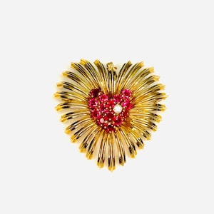 Può includere: Un broche a forma di cuore in oro con un gruppo di rubini rossi e un solo diamante al centro.