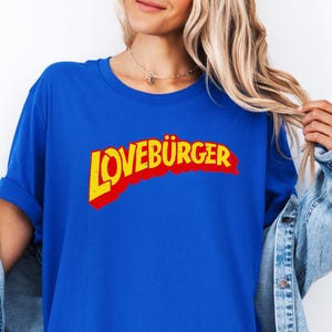 May include: A royal blue t-shirt with a red and yellow graphic that says "LOVEBURGER" in a retro font.
