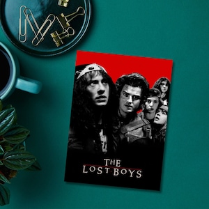K&ouml;nnte beinhalten: Ein Schwarzwei&szlig;-Poster mit rotem Hintergrund, das eine Gruppe junger M&auml;nner und Frauen zeigt. Das Poster tr&auml;gt den Text "THE LOST BOYS" in wei&szlig;en Buchstaben.