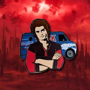 May include: Enamel pin featuring a character with brown hair, wearing a black and red jacket, arms crossed. A blue van with white accents is behind the character. The background is a red, cloudy sky.