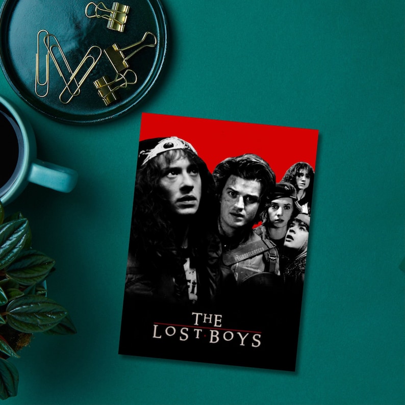 K&ouml;nnte beinhalten: Ein Schwarzwei&szlig;-Poster mit rotem Hintergrund, das eine Gruppe junger M&auml;nner und Frauen zeigt. Das Poster tr&auml;gt den Text "THE LOST BOYS" in wei&szlig;en Buchstaben.