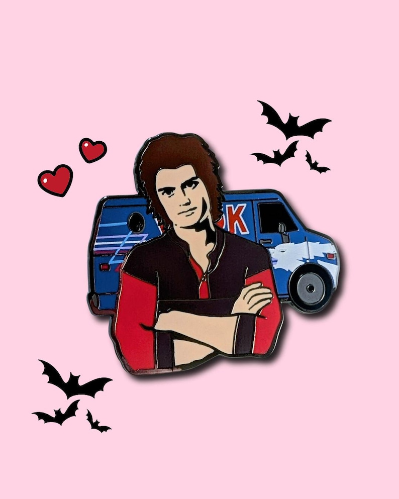 May include: Enamel pin featuring a character with brown hair, wearing a red and black jacket, arms crossed. A blue van is behind the character. The pin is decorated with black bats and red hearts on a pink background.