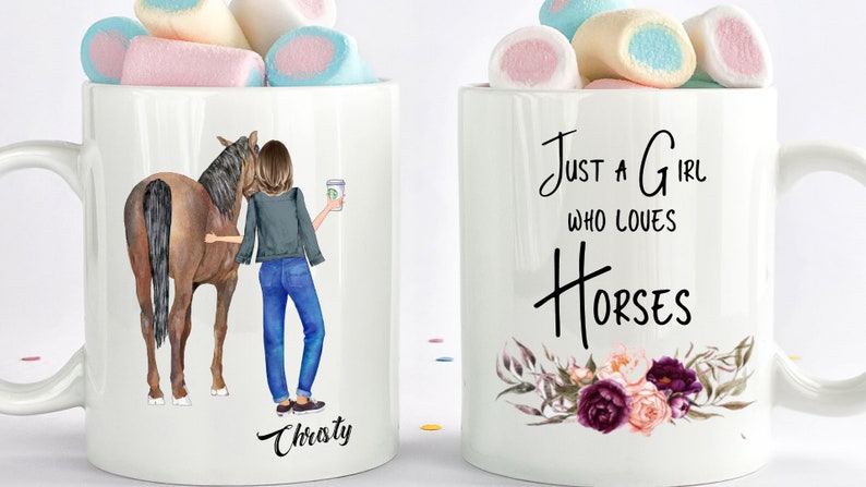 May include: Two white ceramic mugs with black text and images. The mug on the left has a brown horse and a woman holding a coffee cup. The text on the mug reads "Christy". The mug on the right has a floral design and the text "Just a girl who loves horses".