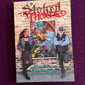 May include: A book cover with a brick wall background. The book title is "Stokes Thorped" in red and black lettering. The cover features a painting of a dragon and other mythical creatures. The text below the painting reads "A book of fantasy art and humour by Anne Stokes & Derick Thorp."