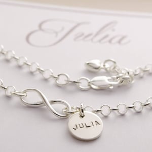 May include: Silver infinity bracelet with a charm that says "JULIA".
