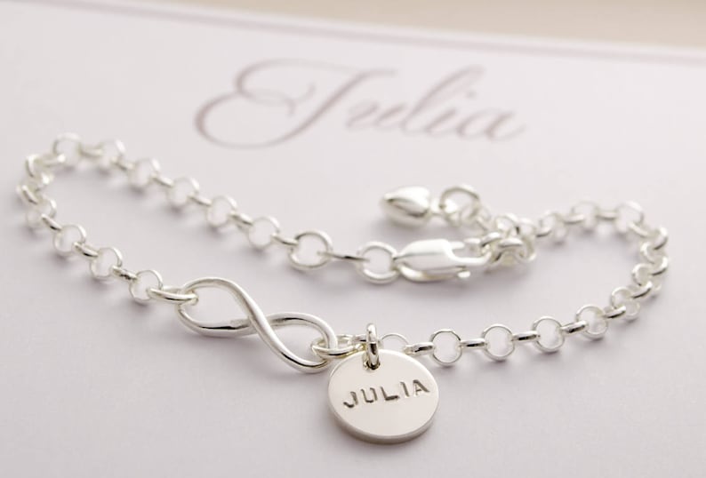 May include: Silver infinity bracelet with a charm that says "JULIA".