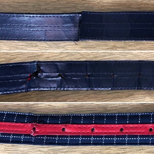 May include: Close-up of three different types of black leather belts with stitching and holes. The first belt has a tear in the leather. The second belt has a larger tear in the leather. The third belt has a red stripe and is stitched with white thread.