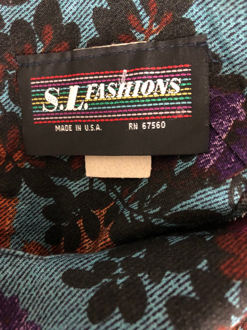 May include: A black fabric label with the text "S.L. FASHIONS" in rainbow colored letters. The label also says "Made in U.S.A." and "RN 57560".