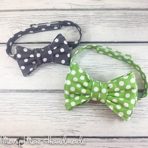 May include: Two bow ties, one black with white polka dots and one green with white polka dots.