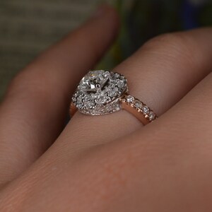 May include: A diamond engagement ring with a halo setting. The ring features a large, round-cut diamond surrounded by smaller diamonds. The band is rose gold and also set with small diamonds.