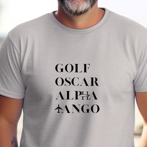 May include: A gray t-shirt with black text that reads "GOLF OSCAR ALPHA TANGO".