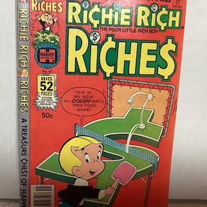 以下が含まれることがあります： ヴィンテージの「リッチー・リッチ」コミックブック。表紙は赤色を基調とし、タイトルは大きな黄色の文字で書かれています。コミックには、リッチー・リッチが卓球をしているイラストが描かれています。「A Treasure Chest of Happiness」というテキストが上部にあります。