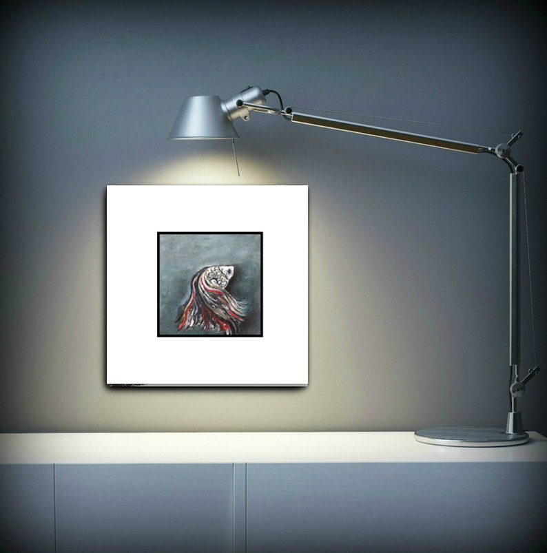 May include: A framed painting of a colorful abstract fish with a white background. The fish is painted in shades of red, white, and blue.