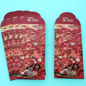 May include: Five red and gold Chinese New Year envelopes with a phoenix design and the text "HSBC Premier" on the front.