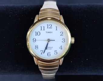 Reloj Timex para mujer Indiglo Easy Reader tono dorado con correa elástica de acero inoxidable, como nuevo.
