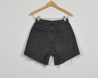 May include: Black denim shorts with a frayed hem. The shorts have two back pockets and a button fly.