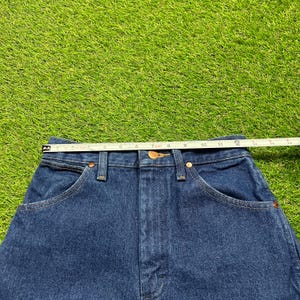 Op de afbeelding: Een donkerblauwe spijkerbroek met een hoge taille en een klassieke vijf-zak stijl.
