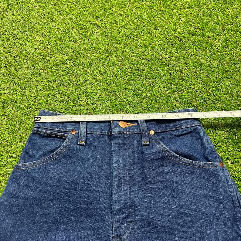 Op de afbeelding: Een donkerblauwe spijkerbroek met een hoge taille en een klassieke vijf-zak stijl.