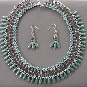 May include: A teal and silver beaded necklace with matching earrings. The necklace features a fringe of teardrop-shaped beads.