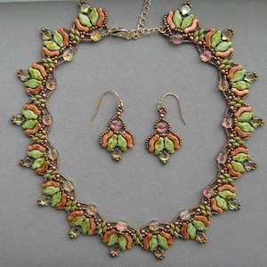 May include: A handcrafted jewelry set featuring a necklace and matching earrings. The set showcases a floral design with green, orange, and pink accents, complemented by iridescent crystals and a gold-tone chain.
