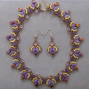 May include: A purple and yellow beaded necklace and matching earrings. The necklace is a circle with a scalloped edge and the earrings are teardrop shaped.