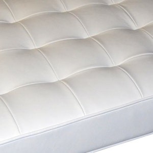May include: White tufted upholstery with a white piping detail. The upholstery is made of a soft, smooth material.