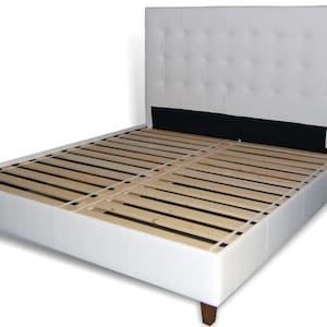 May include: White upholstered bed frame with a tufted headboard and a slatted base.