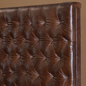 May include: A brown leather headboard with a tufted design. The headboard has a square shape and is made of a thick, durable material.