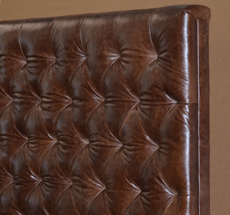 May include: A brown leather headboard with a tufted design. The headboard has a square shape and is made of a thick, durable material.