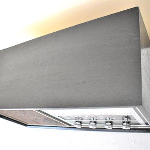 May include: A vintage black stereo receiver with silver knobs and a woodgrain speaker grille.
