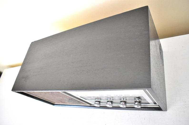 May include: A vintage black stereo receiver with silver knobs and a woodgrain speaker grille.