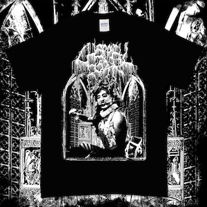 以下が含まれることがあります： ゴシック調の背景に白いグラフィックプリントが施された黒いTシャツ。グラフィックには、長い髪と王冠をつけた人物が、大きな窓のあるドアの横に立っている様子が描かれている。グラフィックの上に「GHOST」という文字がプリントされている。