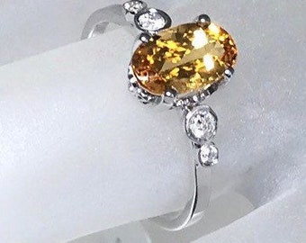1,40 carats imperial topaz oval cut in center and 0,08 carats natural  diamonds G color SI1 on the side 14 karat