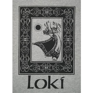Puede incluir: Una camiseta gris con una ilustración en blanco y negro de una figura con una capa y un sol detrás. La ilustración está enmarcada con un borde adornado en blanco y negro. La palabra "LOKI" está impresa en negro debajo de la ilustración.