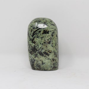 May include: A smooth, green and black polished stone with a unique marbled pattern.