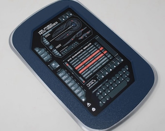 May include: A rectangular dark blue and silver prop tablet featuring a black screen display with the text USS ATHENA NCC-392023, SYS DIAGNOSTIC RESULTS, and DIAGNOSTIC LEVEL 3. The screen includes various technical diagrams, system status lists, and a keyboard layout.