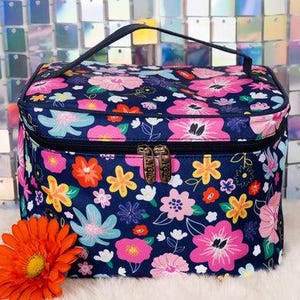 May include: A blue floral print makeup bag with a zipper closure. The bag has a variety of colorful flowers and leaves on a dark blue background.