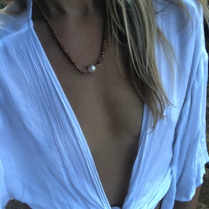 Sandalwood beauty featuring an Edison pearl encased in Kahelelani shells with 14k gold fill spacers throughout