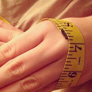 Puede incluir: Una cinta m&eacute;trica amarilla envuelta alrededor de la mu&ntilde;eca de una persona, mostrando una medida de 15,24 cm.