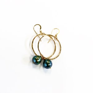 May include: Gold hoop earrings with a dark green pearl dangling from each hoop.