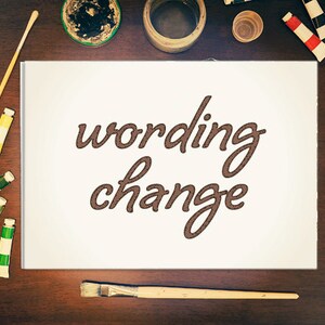 Peut inclure: Une toile blanche avec l'inscription "wording change" en script marron est entourée de fournitures artistiques. Des tubes de peinture, des pinceaux et des récipients de peinture sont disposés sur une surface en bois foncé, suggérant un thème artistique ou de design.