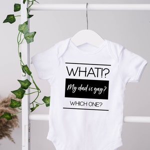 May include: White baby onesie with black text that reads "WHAT? My dad is gay? WHICH ONE?"