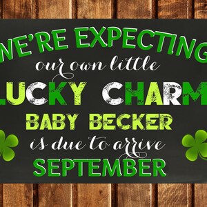 Puede incluir: Una pizarra negra con acentos de trébol verde anuncia un embarazo con el texto "WE'RE EXPECTING our own little LUCKY CHARM BABY BECKER is due to arrive SEPTEMBER".
