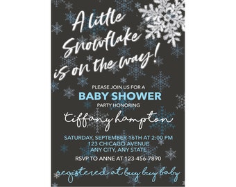 May include: A black and blue baby shower invitation with a snowflake design. The text reads "A little snowflake is on the way!" and includes the date, time, and location of the event. RSVP information is also included. The invitation says "registered at buy buy baby".