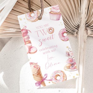 May include: A white ceramic mug with a black handle and the text "But First, Coffee" in a bold, black font. The mug is set against a blurred background, highlighting its clean design.