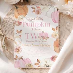 May include: A rectangular invitation card with the text "Our Little Pumpkin Is Turning TW" in pink. The card features watercolor pumpkins and floral accents in shades of orange, pink, and white. The invitation is for Olivia's Second Birthday.