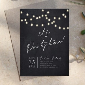 Black birthday party invitation with glowing string lights across the top and large white It's Party Time lettering. The modern layout includes customizable party details beneath the main wording. The printable invitation is displayed on a neutral stone surface with subtle greenery nearby. The design works well for an adult birthday, backyard party, BBQ or casual outdoor gathering.