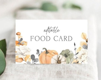 May include: A white rectangular food card with the text "editable FOOD CARD" in gray. The card is decorated with watercolor pumpkins, cotton, and floral elements in shades of orange, green, and cream. The bottom of the card reads "THE PRINTABLE OCCASION."