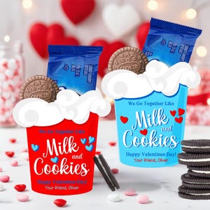May include: Two decorative cups, one red and one blue, with the words "Milk and Cookies" and Valentine's Day greetings. Each cup holds a chocolate sandwich cookie and a blue package of cookies. The cups are decorated with hearts.